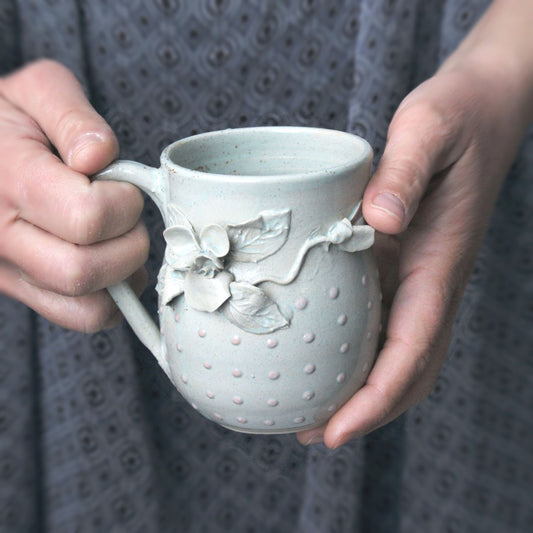 Tazza in gres azzurra con fiore di viola del pensiero e puntini a rilievo