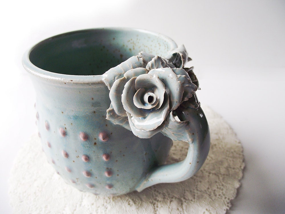 Tazza Alice in gres azzurro con rose bianche e puntini rosa in rilievo, fatta a mano al tornio